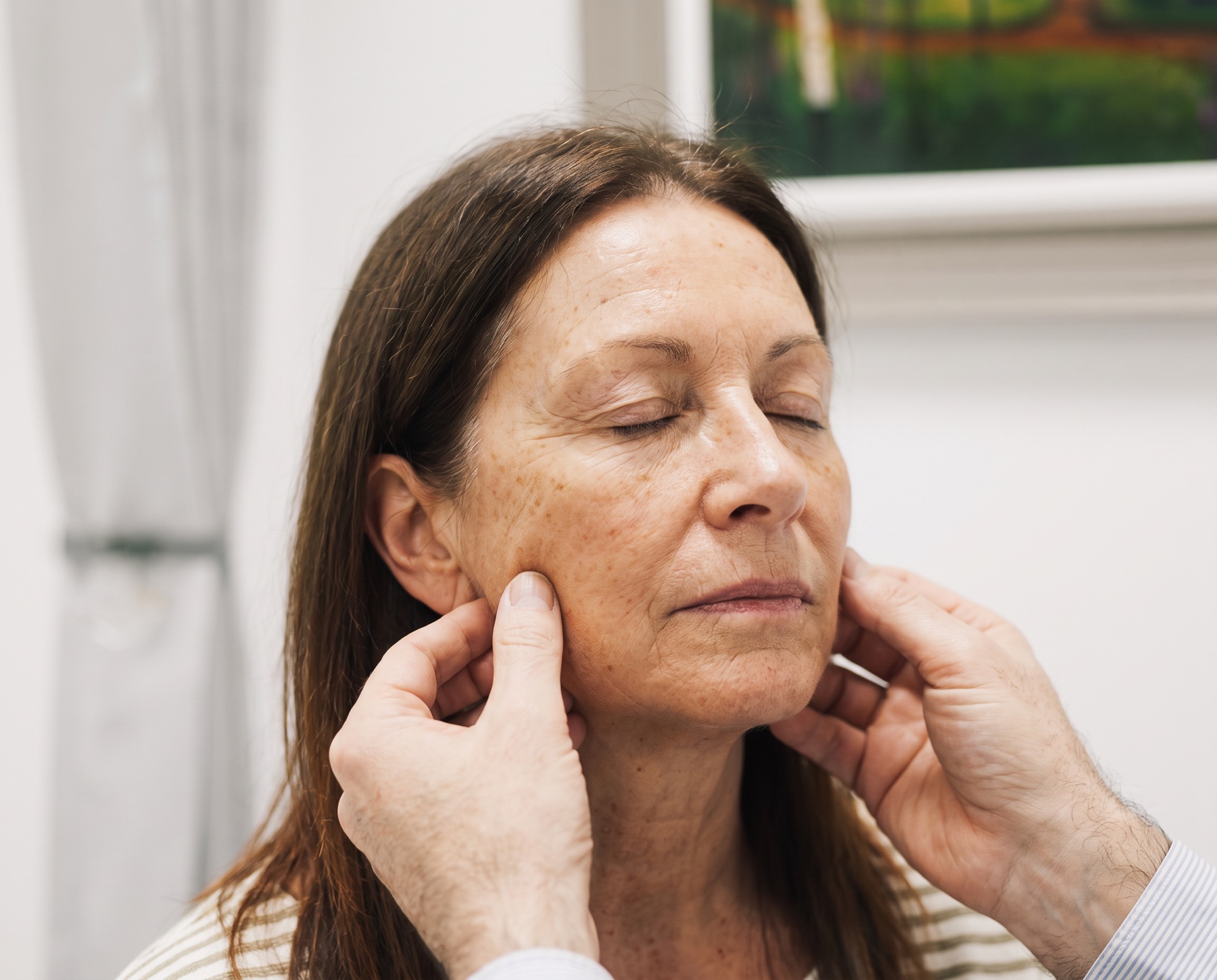 Consultant showing the effect of a facelift during assessment